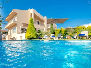 Een buitenzwembad, parasols voor strand/zwembad