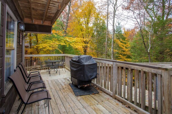 A wooden deck with outdoor seating and a grill. - Happy Trails- easy access, 3 minute drive to Pigeon Forge (Pigeon Forge)