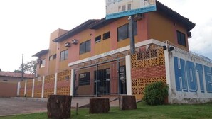 A hotel named "Pousada Mosaic" with a brick facade, a gated entrance, and a sign indicating the hotel's name. - Hotel Pousada Mosaico (Palmas)