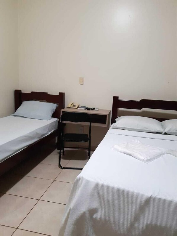 A small, clean room with two single beds, a desk, and a chair. - Hotel Pousada Mosaico (Palmas)