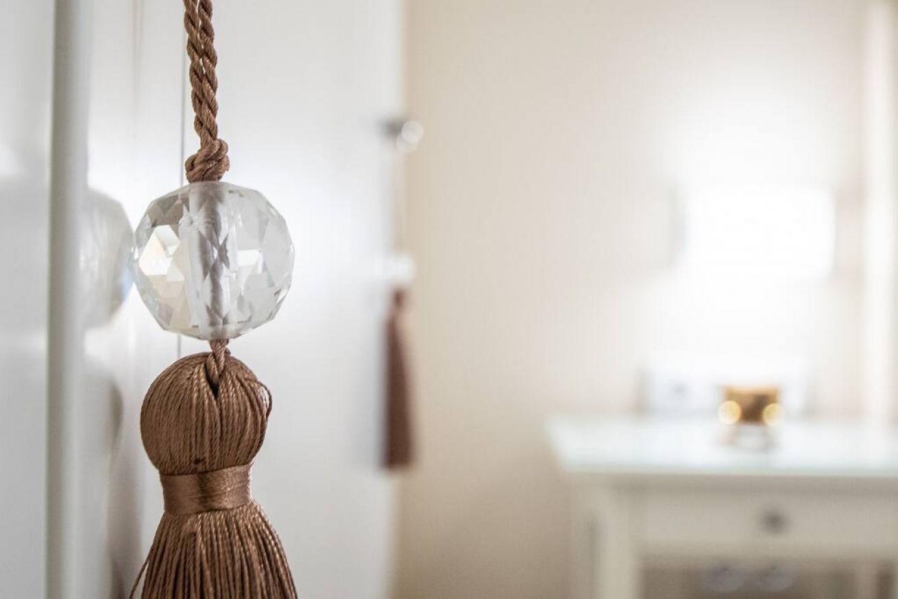 A chandelier with a crystal globe and a braided rope.