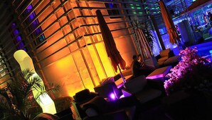 An indoor lounge area with seating and a large illuminated structure in the background. - Breakfast on the balcony with Treehouse vibe, garden, barbecue, reservoir, thermal spa (Nordhalben)