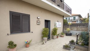 A building with a balcony, potted plants, and a door. - B&B Lavika Pedara (Pedara)