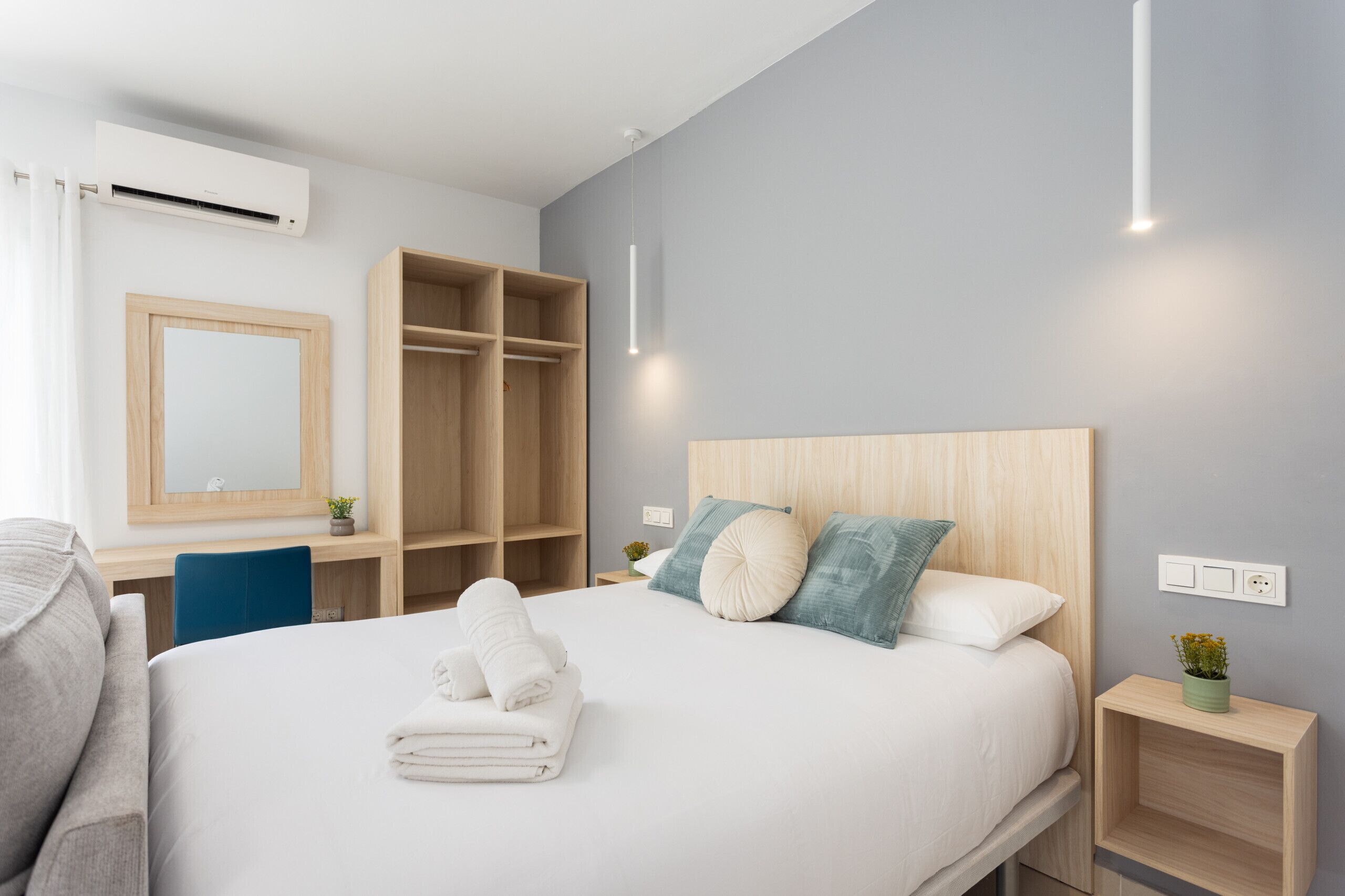 Ein modernes Hotelzimmer mit einem großen Bett, einem Schreibtisch und einem Kleiderschrank.