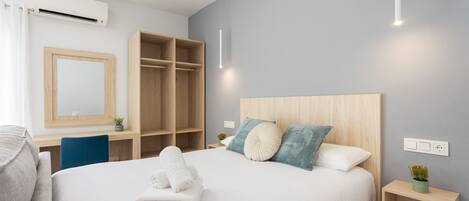 Ein modernes Hotelzimmer mit einem großen Bett, einem Schreibtisch und einem Kleiderschrank.