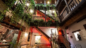 A multi-level interior with a staircase, wooden beams, and a balcony with greenery. - Entre Dos Aguas Hotel Boutique (Toledo)
