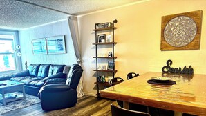 A living room with a sofa, a dining table, and a bookshelf. - Water View Villa-monthly rate discount (EVERGLADES CITY)