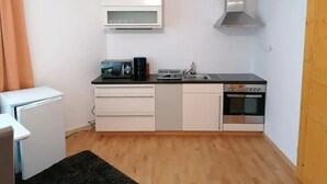A compact kitchen with a microwave, toaster, sink, and oven.