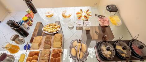 Un bufé de desayuno con diversos pasteles, panes y bebidas.