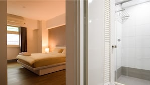 Una camera da letto con un letto, un comodino e una finestra con tende.