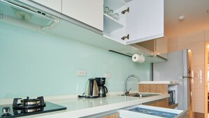 Una cucina moderna con lavastoviglie integrata, macchina da caffè e piano cottura.