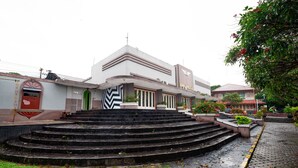 Un edificio con un diseño arquitectónico moderno, con una escalera que conduce a la entrada.
