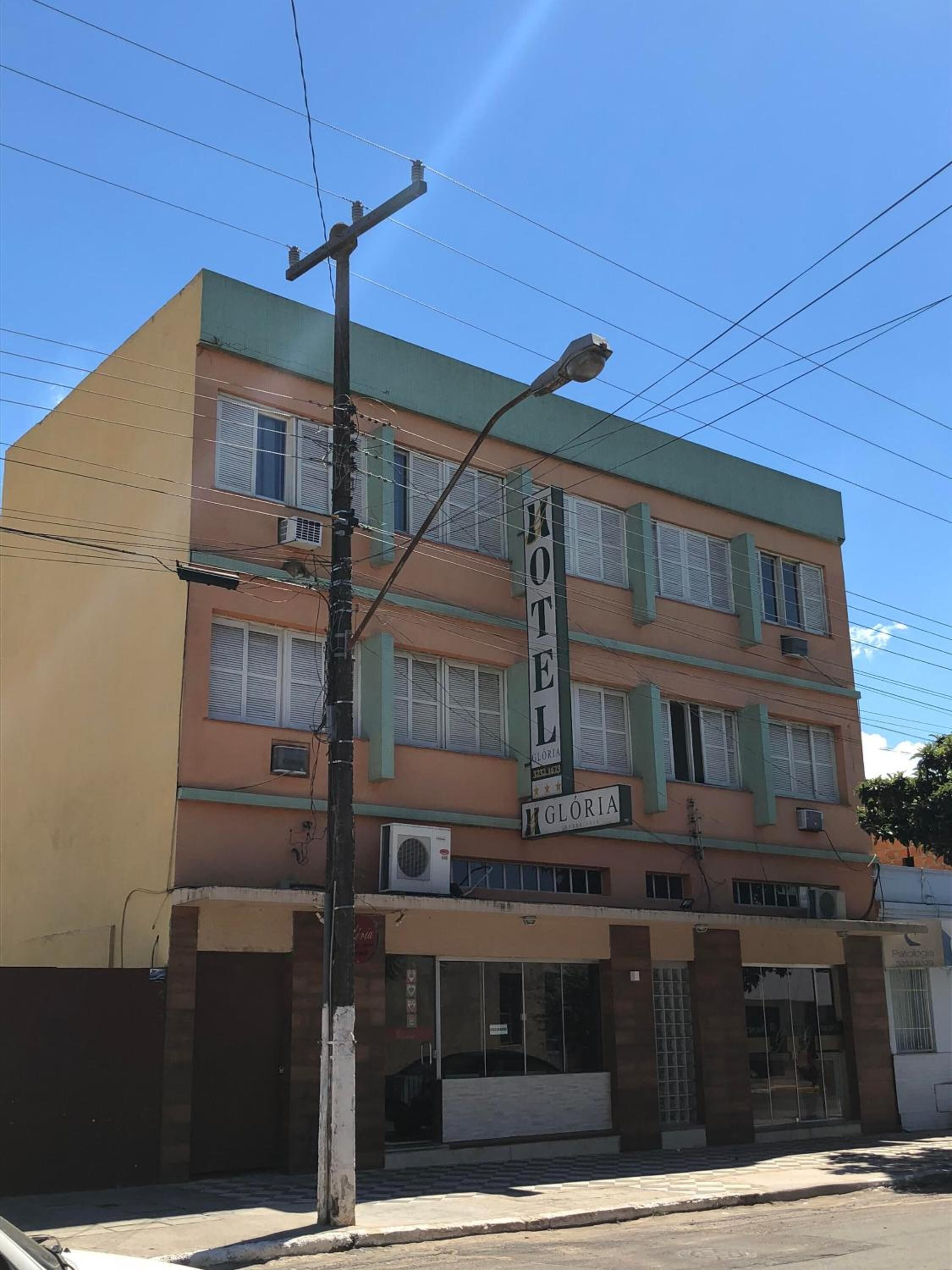 Un edificio de varios pisos con un cartel que dice 'HOTEL GLORIA'.