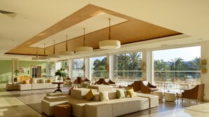 A spacious lobby with a large seating area, large windows, and a high ceiling. - Occidental Sousse Marhaba (Sousse)