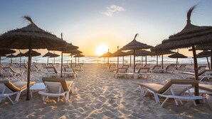A beach with rows of sun loungers and thatched umbrellas, arranged for sunbathing. - Occidental Sousse Marhaba (Sousse)