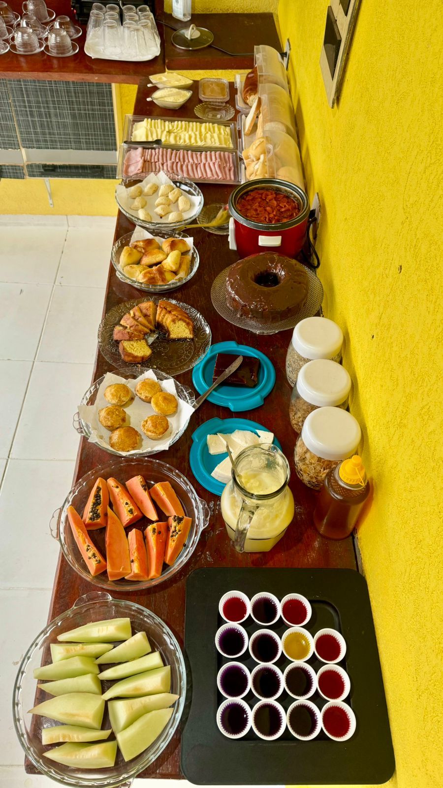 A buffet table with various food items and condiments.