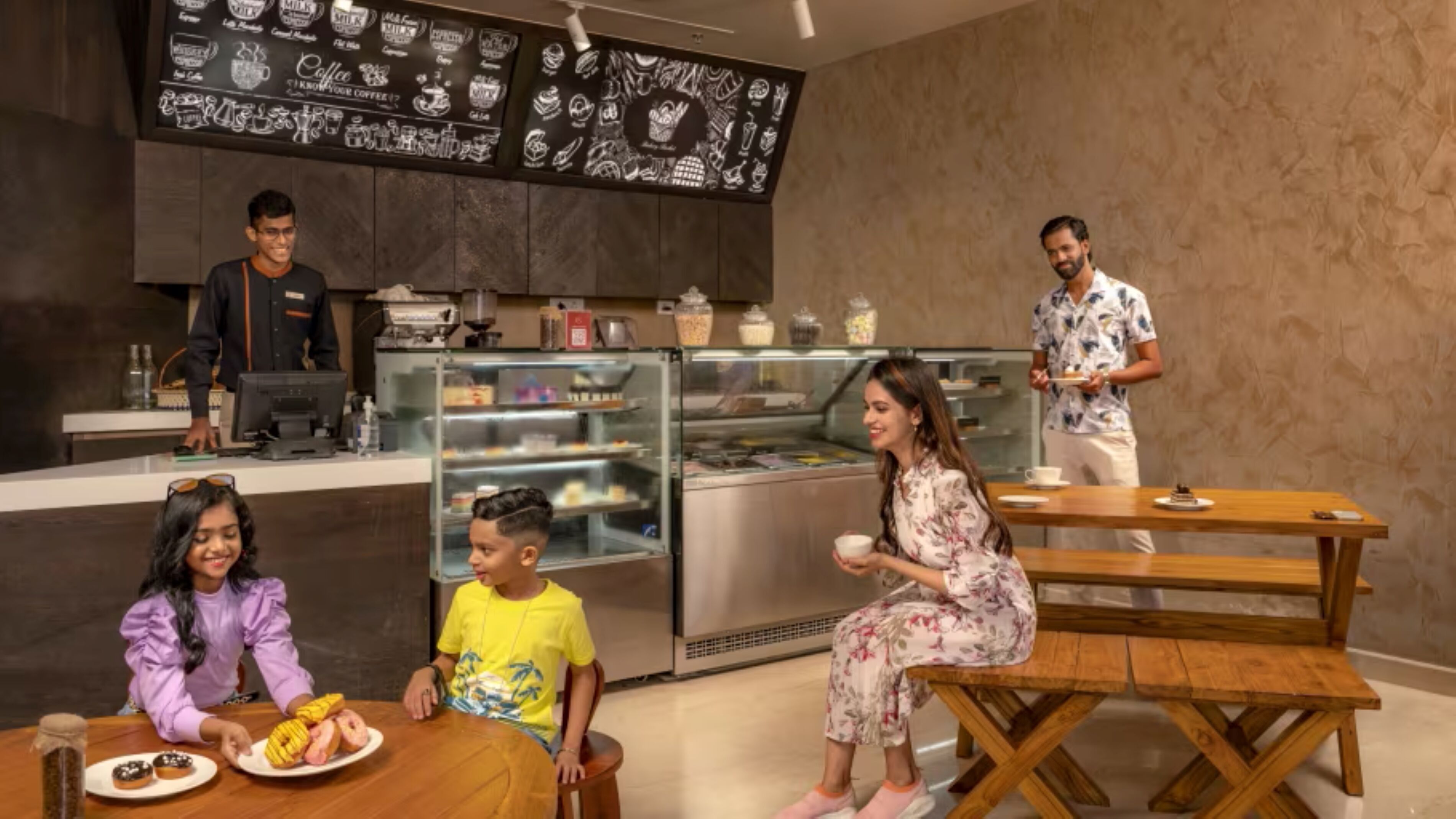 A cozy cafe with a wooden table, a counter, and a display case with pastries.