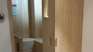 Une pièce en bois avec un banc intégré et une petite table avec une lampe.