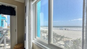 A room with a large window overlooking a beach. - Beach House 107 - Two Bedroom, Two Bath Oceanfront Condo (Garden City Beach)