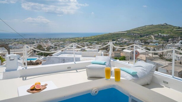 Terraço no telhado com piscina, duas espreguiçadeiras e uma mesa com frutas cítricas.