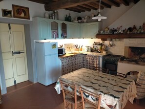 A kitchen with a refrigerator, stove, and wooden cabinets.