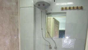 Un baño pequeño con inodoro, ducha y espejo.