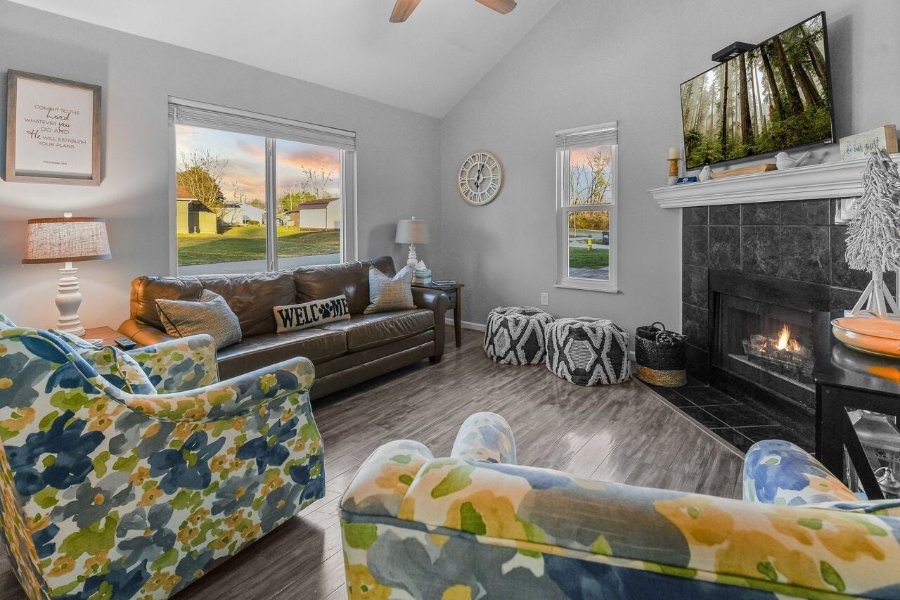 A living room with a fireplace, a sofa, a coffee table, and a television.