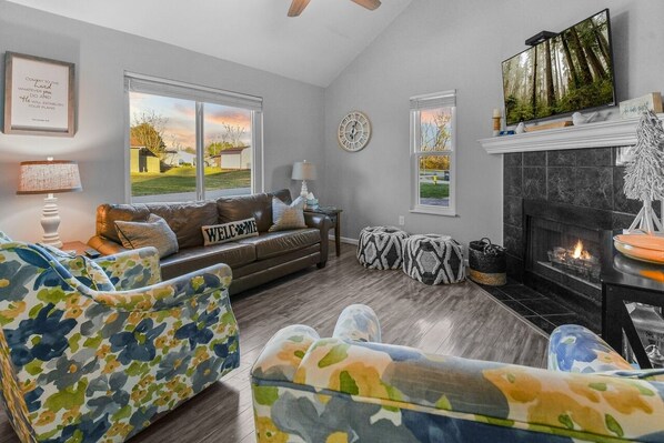 A living room with a fireplace, a sofa, a coffee table, and a television. - Rotties' 2 Bedroom Home by RedAwning (Pigeon Forge)