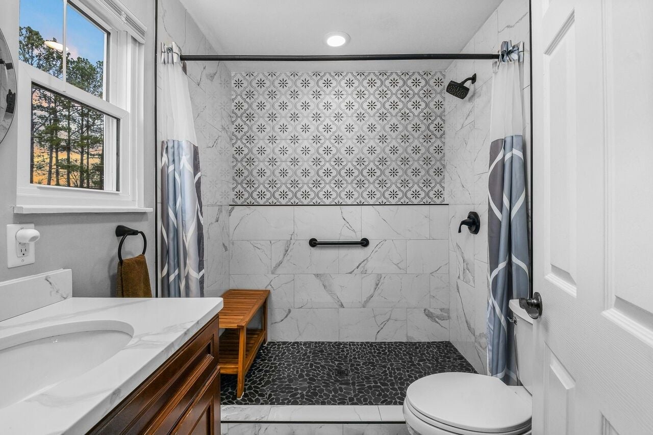 A bathroom with a shower, toilet, and vanity.