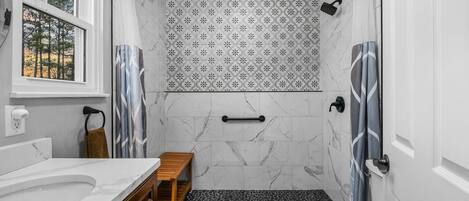 A bathroom with a shower, toilet, and vanity.