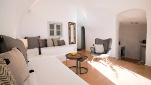 Un salon moderne avec un canapé blanc, un fauteuil gris et une petite table ronde ornée de citrons.