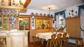 Un coin repas en bois avec une table dressée pour quatre personnes, entourée de chaises en bois.