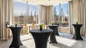 A modern hotel room with large windows, a round table, and a potted plant. - Park Inn by Radisson Vilnius Airport Hotel & Conference Centre (Vilnius)
