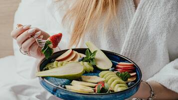 Una persona sosteniendo un tazón de ensalada de frutas.