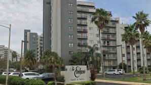 A multi-story hotel with a sign reading "The Enclave Hotel & Suites". - 2 BR RESORT IN PERFECT LOCATION NEAR UNIVERSAL (Orlando)