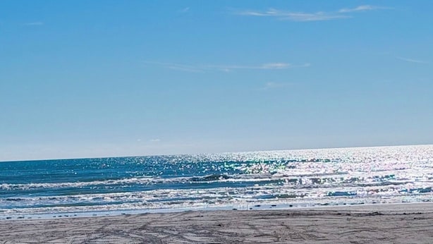 Una playa con olas y cielo despejado.