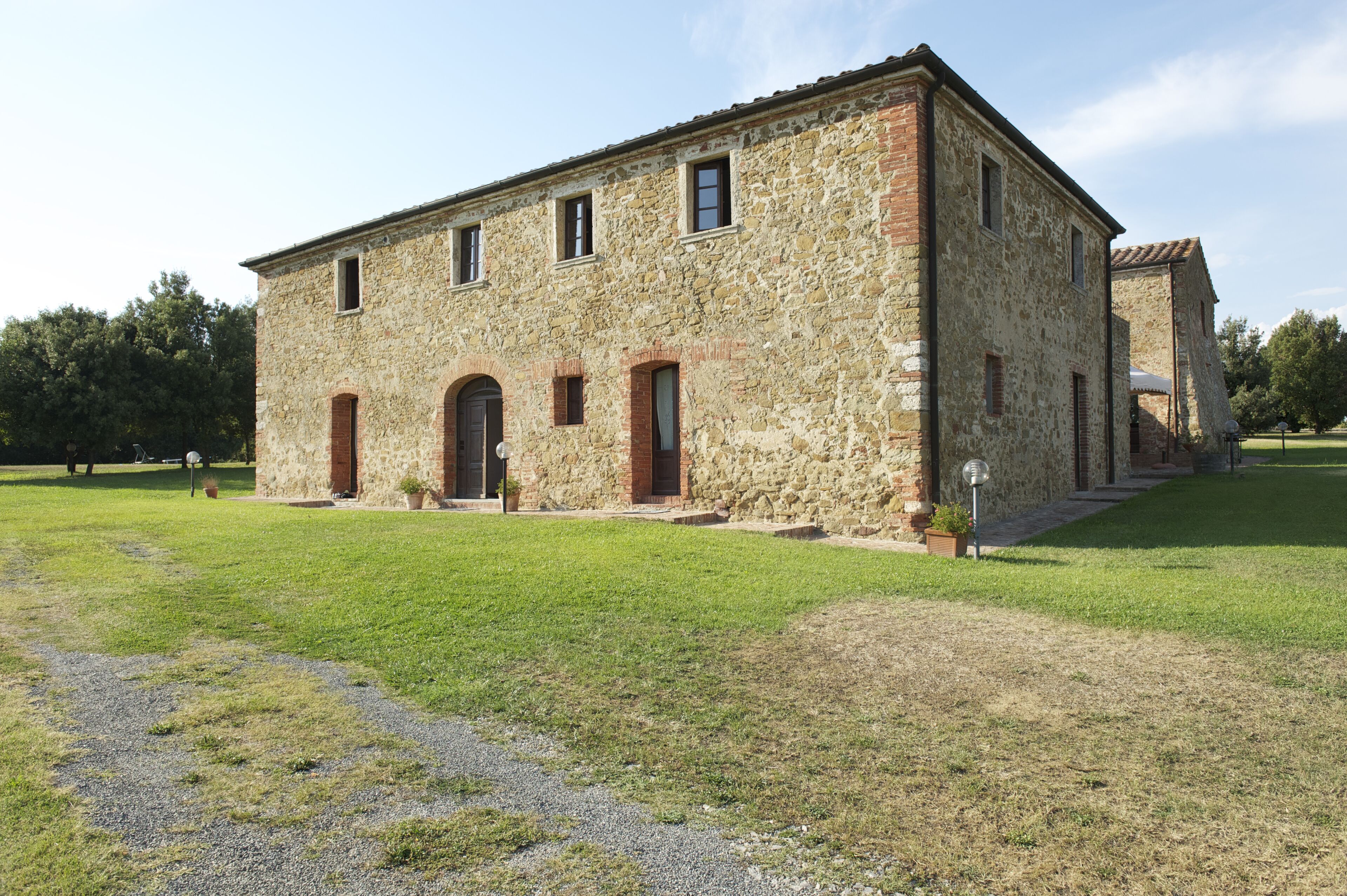 Un edificio de piedra con forma rectangular, múltiples ventanas y una entrada central.