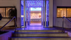 The entrance to Seagull Hotel Apts with a modern design, featuring a glass door entrance and a staircase leading up to the lobby. - Seagull Hotel Apartments (Paralimni)