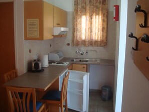 A compact kitchen with a sink, a toaster, and a small refrigerator. - Seagull Hotel Apartments (Paralimni)
