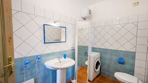 A bathroom with a sink, mirror, washing machine, and toilet. - Pedra De Oro | 2 Bedroom and Sea View! (Budoni)