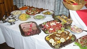 Een buffet met diverse gerechten, waaronder salades, vleeswaren en desserts.