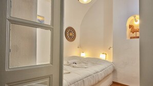 Camera da letto con un letto, due abat-jour, una sveglia a muro e una scultura decorativa a forma di cavallo.