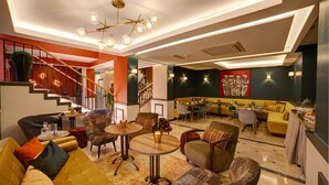 A modern hotel lobby with a staircase, seating areas, and a dining space. - The Fox Hotel (Istanbul)