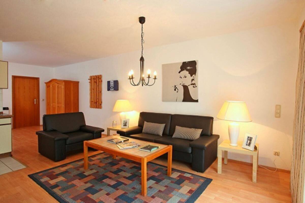 Un salon comprenant un canapé, une table basse, une lampe et un lustre.