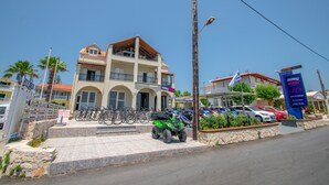 Ein mehrgeschossiges Gebäude mit Balkon, abgestellten Fahrrädern und Quads.