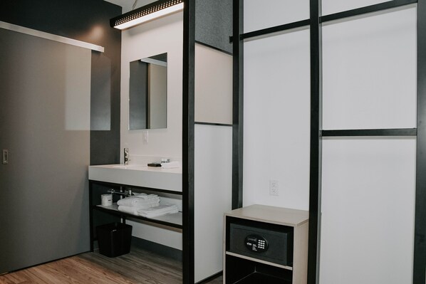 A modern bathroom with a large mirror, a sink, and a storage cabinet.