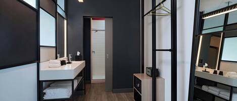Un baño moderno con tocador, espejo y toallero.