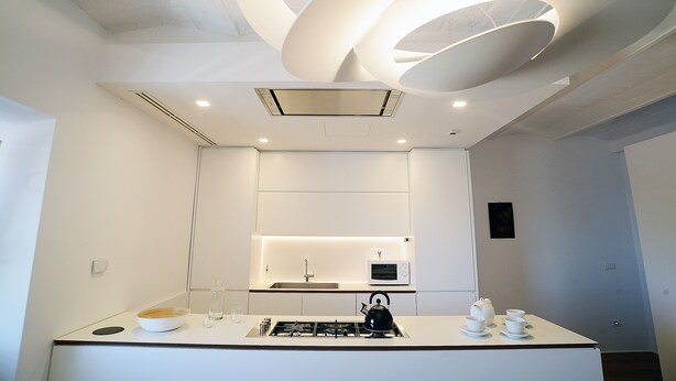 A modern kitchen with a built-in microwave, kettle, and tea set on the counter. - Beautiful apartment in the center of Rome (Roma)