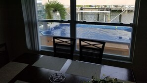 A room with a large window overlooking a pool and outdoor area. - Beautiful Matlacha Isles direct access waterfront home with dock, lift and deck (Matlacha)