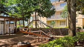 A playground with a seesaw, tire swings, and a climbing structure. - Milele Resort Nakuru (Nakuru)